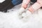 Girl in Winter snowy day, a woman warm knitted mittens and boots sitting in the snow and making snowballs , snow, image advertisin