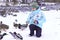 A girl on a winter walk in a city park feeds wild mallards with bread.