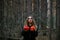 Girl witch witch pumpkin on halloween in a dark pine forest