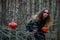 Girl witch witch pumpkin on halloween in a dark pine forest