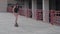 girl or woman skates on a skateboard in front of a building in short denim shorts