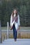 Girl on the wooden jetty at a lake in autumn season