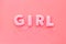 Girl word as decoration for baby shower on pink background top view