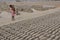 A girl working in the brick factory carries her young brother on her back