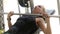 A girl works out in the gym lifting the barbell training breast muscles