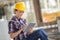 girl in workwear safety helmet using tablet touchpad