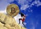 The girl, wrapped in a flag of Denmark, raises a bitcoin coin up the hill