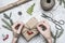 Girl wraps a gift for a new year or Christmas, next to it is a roll of paper, vintage scissors, twigs of Christmas trees and berri