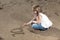 Girl writing number in the sand