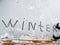 The girl wrote the word winter in the snow with her boot
