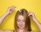 Girl on a yellow background with a mesoroller. Mesotherapy for hair and scalp. Cosmetology, hair and body care