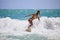 Girl in a yellow bikini surfing