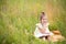 Girl in a yellow dress sits in the grass on a blanket in a field and reads a paper book. International Children`s Day. Summer tim