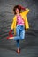 Girl in a yellow jacket and blue jeans with an afro hairstyle. Fashion of the eighties, disco era.