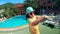 Girl in yellow shirt dances near pool.