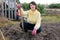 Girl in a yellow sweater digs beds with a shovel