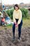 Girl in a yellow sweater digs beds with a shovel