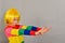 A girl in a yellow wig points to a place for an advertising product, a bright colored child on a gray background