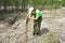 Girl zoologist sets a camera trap for observing wild animals in the taiga forest to collect scientific data. Environmental