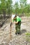 Girl zoologist sets camera trap for observing wild animals in taiga forest to collect scientific data. Environmental protection,