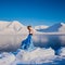Girlbeautiful blonde in a blue summer dress on a background of blue mountains svalbard on the Spitsbergen cit