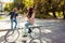 Girlfriend riding bike and boyfriend grimacing