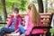 Girlfriends with face masks talk while sitting on a bench in the playground