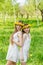Girlfriends are standing with wreaths of dandelions on their heads