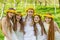 Girlfriends are standing with wreaths of dandelions on their heads in the open air