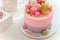 Girlish pink cake with baubles, golden crown and number 1. One year old first birthday party.