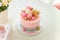 Girlish pink cake with baubles, golden crown and number 1. One year old first birthday party. Candy bar with flowers