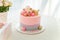 Girlish pink cake with baubles, golden crown and number 1. One year old first birthday party. Candy bar with flowers and present b