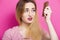 Girls with anxious face combing hair with a wooden comb on a colored background, concept of beauty, body care, hair problems,