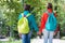 Girls backpackers friends fleece clothes backpacks forest background, hand in hand concept