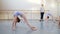 Girls at ballet gymnastics class doing bridge pose exercise, dance school group.