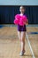 Girls in black sportswear with pink pompoms on gym, attractive young cheerleader working out in sports club, cheerleader with pom-