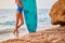 Girls body and surfboard on coastline. Summer trip and surfing hobby idea. Adventure and beach time concept. Copy space