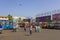 girls and boys walk in the background parked bright colorful buses at the bus station