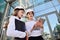 Girls in building white helmets with tablets in hands on the background of a glass office building. Women are engineers. Female p