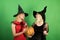 Girls celebrates Halloween. Stylish girls best friends ready for party, over green background. Two beautiful women