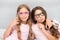 Girls children posing with grimaces photo booth props. Pajamas party concept. Girls friends having fun pajamas party