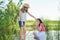 Girls children on wooden pier of lake in reeds, playing with water, talking