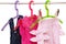 Girls clothes on rack. Close-up of colorful stylish summer dresses and a short pants for the little girl on a rack isolated on a