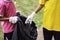 The girls collected plastic bottles of garbage into black bags at the park