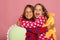 Girls in colorful polka dotted pajamas hold funny bright pillows