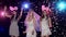 Girls dancing at bachelorette party against stroboscope lamps glitter confetti