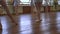 Girls do ballet exercises during ballet lesson in classroom with frayed floor.