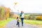 Girls fly an kite on autumn or fall meadow