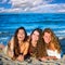 Girls friends having fun happy lying on the beach