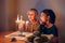 Girls friends lighting candles on menorah for traditional Jewish Hanukkah holiday. Children celebrating Chanukah festival